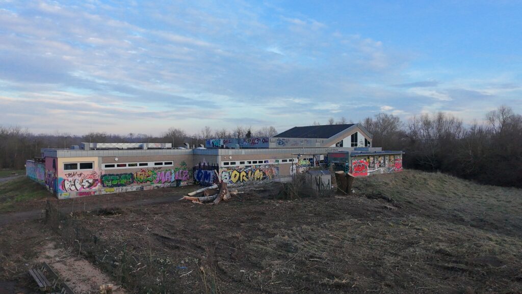 Rund um das alte Hallenbad der VG Rhein-Selz wurden am 21. Februar Bäume gefällt und Gestrüpp und Bewuchs gerodet, um den Zugang für den Abriss des Gebäudes freizumachen. (Foto: Andreas Lerg)